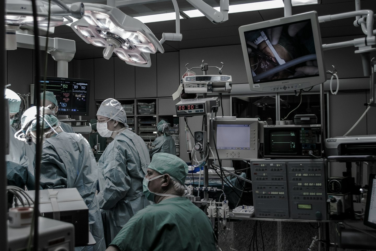 Team medico che esegue un intervento chirurgico con monitor e attrezzature.